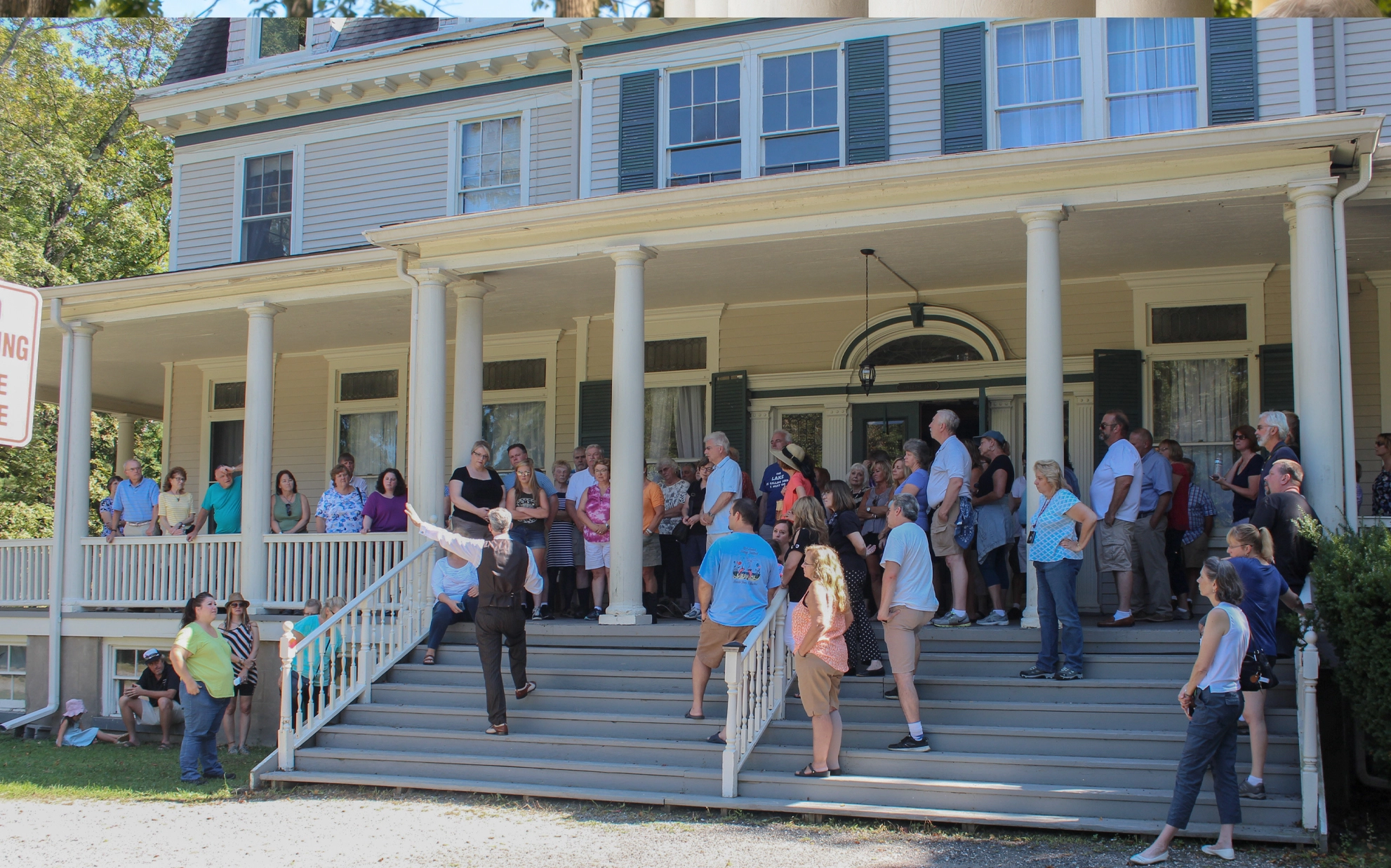 Visitors gathered for a public tour on the porch at Idylease